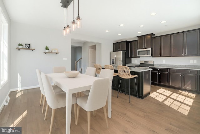 dining room with recessed lighting, baseboards, stairway, and light wood finished floors