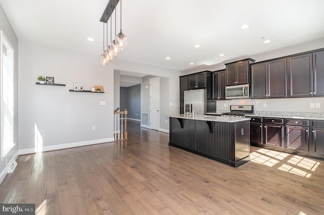 kitchen with light wood-type flooring, recessed lighting, baseboards, and appliances with stainless steel finishes