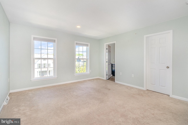 unfurnished bedroom featuring baseboards and light carpet