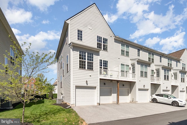 view of front of house featuring a residential view, an attached garage, cooling unit, and driveway