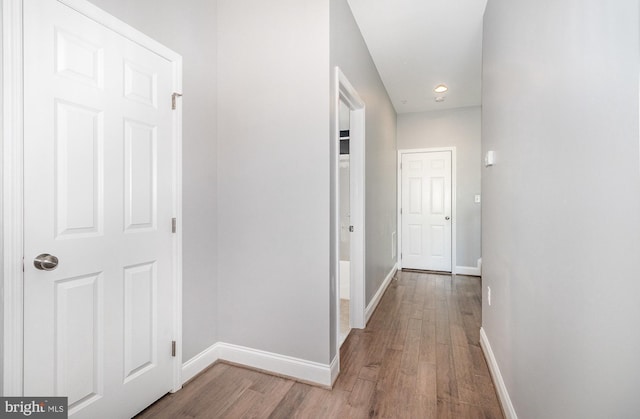 corridor featuring recessed lighting, baseboards, and wood finished floors