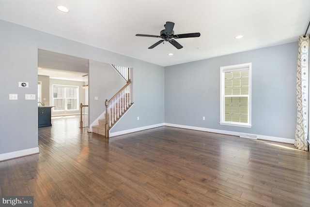 spare room with dark wood finished floors, stairs, a ceiling fan, baseboards, and recessed lighting