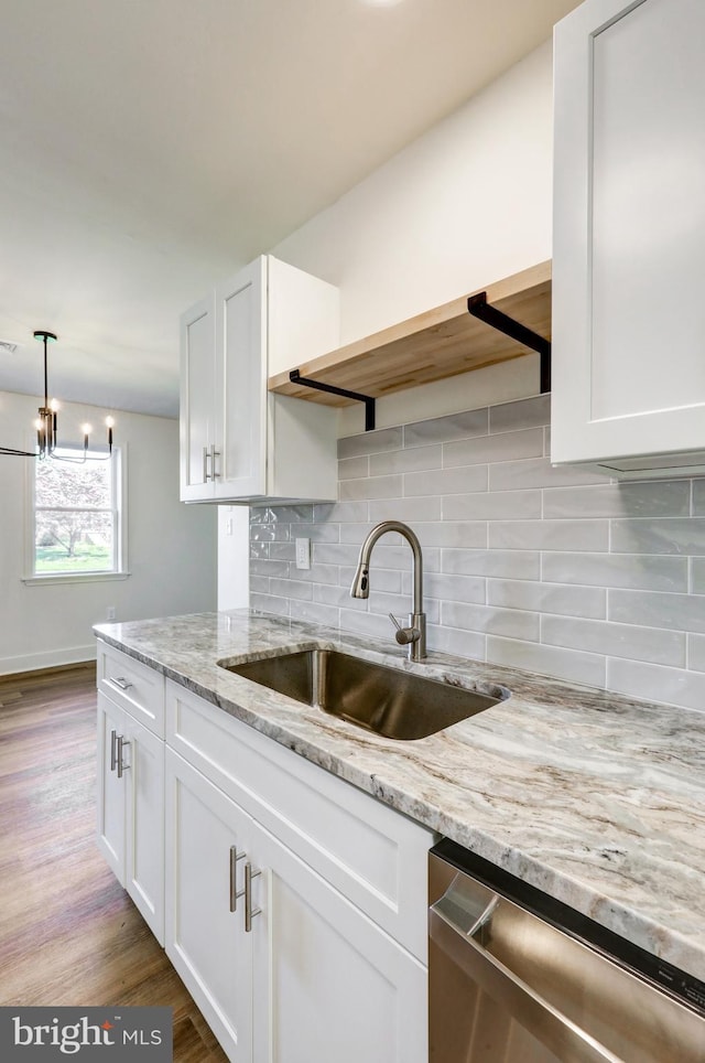 kitchen featuring a sink, tasteful backsplash, stainless steel dishwasher, and white cabinetry