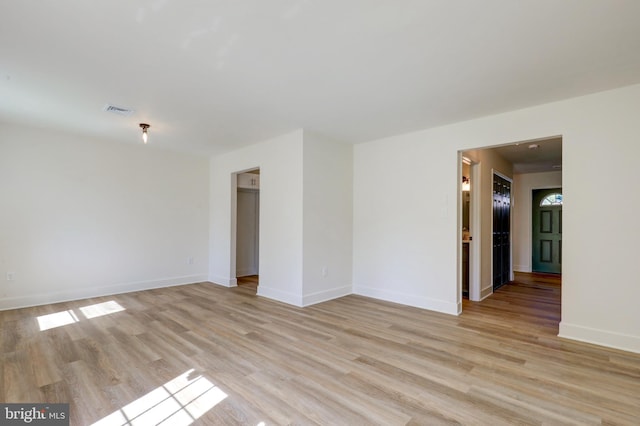 spare room featuring baseboards, visible vents, and light wood-type flooring