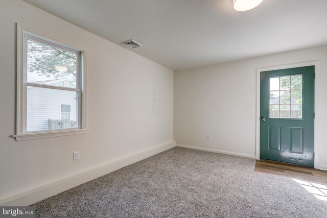 carpeted entrance foyer with baseboards and visible vents