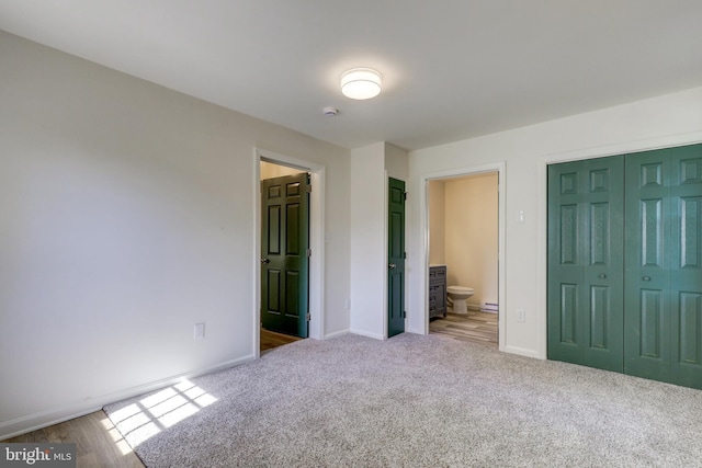 unfurnished bedroom featuring baseboards, a closet, carpet floors, and connected bathroom