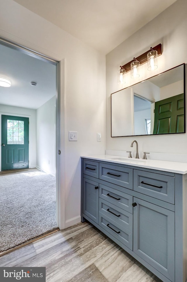 bathroom featuring vanity, baseboards, and wood finished floors