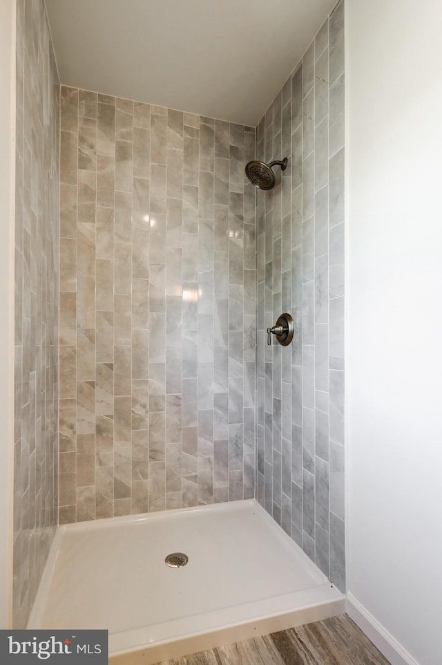 bathroom featuring wood finished floors and tiled shower