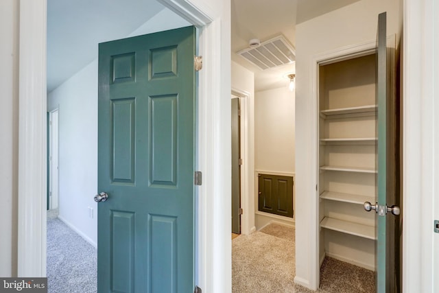 hall featuring baseboards, carpet, and visible vents