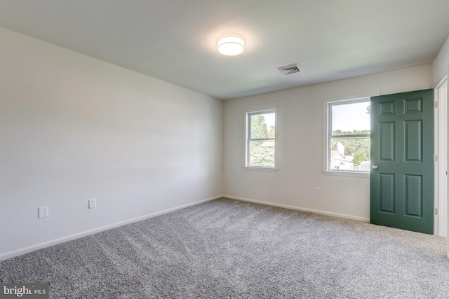 empty room with visible vents, carpet, and baseboards