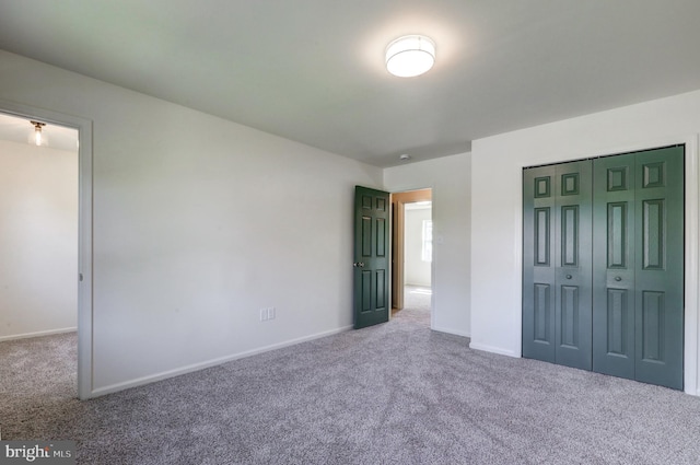 unfurnished bedroom featuring baseboards, carpet flooring, and a closet