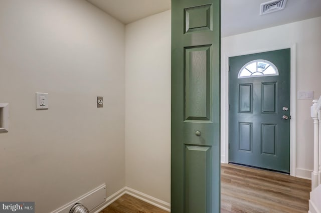 foyer entrance with baseboards, visible vents, and wood finished floors