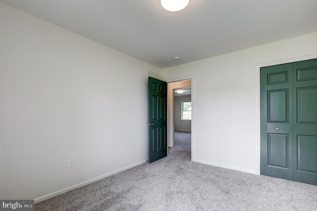 unfurnished bedroom featuring carpet flooring and baseboards