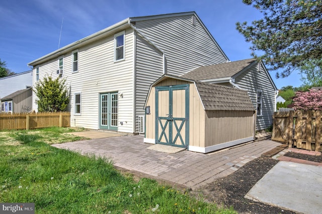 back of house featuring a storage shed, fence, an outdoor structure, and a patio area