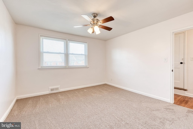 empty room featuring a ceiling fan, baseboards, visible vents, and carpet