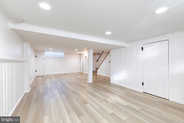 basement featuring light wood-style floors, recessed lighting, stairs, and baseboards