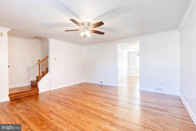 unfurnished room featuring ceiling fan, visible vents, light wood-style floors, ornamental molding, and stairs