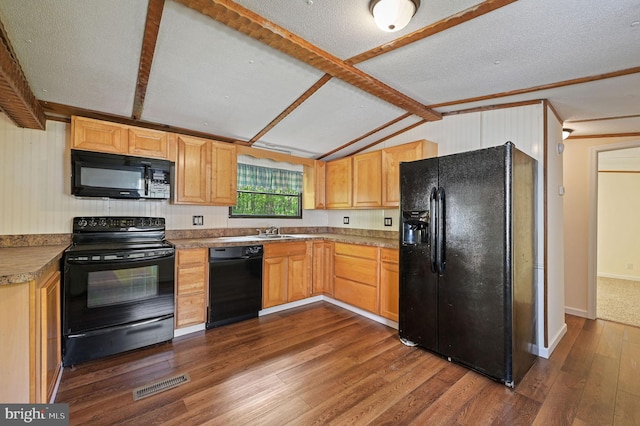 kitchen featuring visible vents, dark wood finished floors, a sink, black appliances, and vaulted ceiling with beams