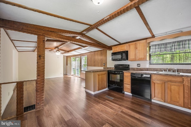kitchen featuring a peninsula, lofted ceiling with beams, dark wood-style floors, a sink, and black appliances