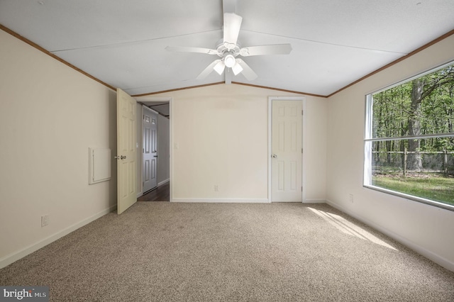 interior space with a ceiling fan, baseboards, vaulted ceiling, and ornamental molding