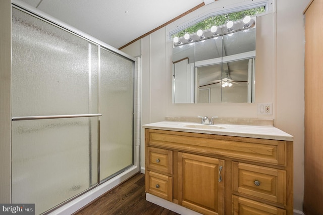 full bathroom with vanity, a ceiling fan, wood finished floors, and a stall shower