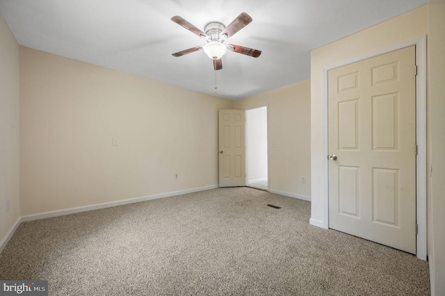 unfurnished bedroom featuring carpet floors, a ceiling fan, baseboards, and visible vents