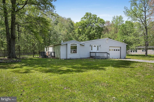 view of front of home featuring fence, a garage, driveway, and a front yard