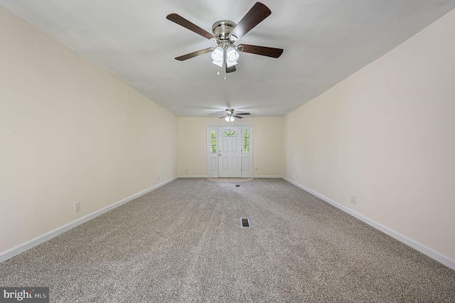 unfurnished room featuring baseboards, ceiling fan, visible vents, and light carpet