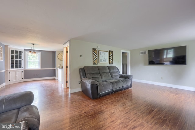 living room with visible vents, wood finished floors, and baseboards