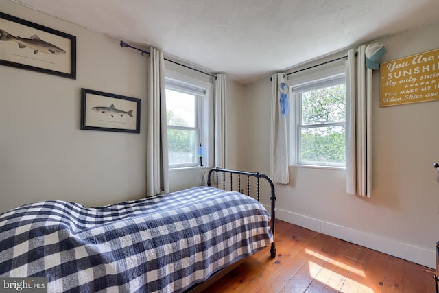 bedroom featuring hardwood / wood-style flooring and baseboards