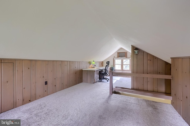 bonus room featuring vaulted ceiling, wood walls, and carpet flooring