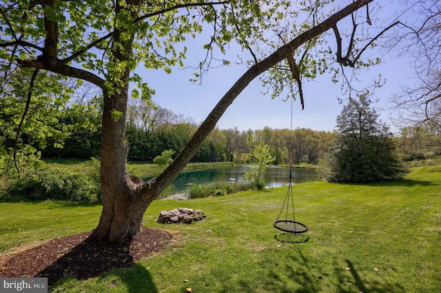 view of home's community featuring a forest view, a yard, and a water view