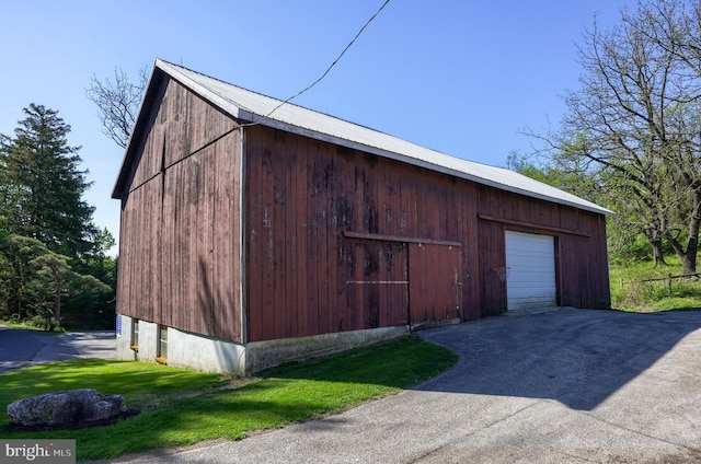 view of barn with aphalt driveway