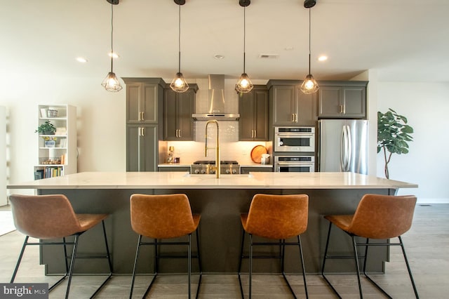 362 Star Tavern Ln, West Chester, PA 19382 - kitchen featuring visible vents, a spacious island, wall chimney range hood, light wood-style flooring, and appliances with stainless steel finishes