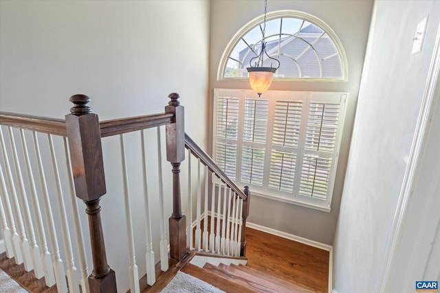 stairway featuring baseboards and wood finished floors