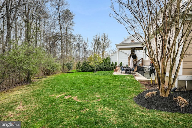 view of green lawn featuring a patio area