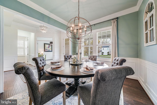 dining space featuring a decorative wall, a chandelier, a wainscoted wall, ornamental molding, and dark wood-style floors