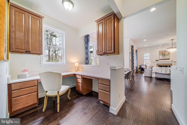 home office with built in study area, dark wood finished floors, a fireplace, baseboards, and recessed lighting