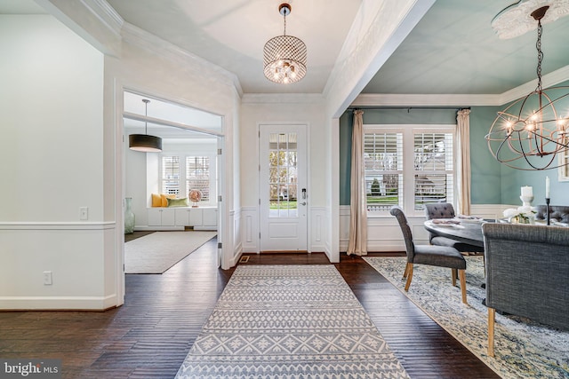 foyer entrance featuring a chandelier, crown molding, hardwood / wood-style flooring, and a wainscoted wall