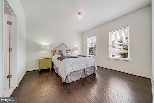 bedroom featuring baseboards and dark wood-style flooring