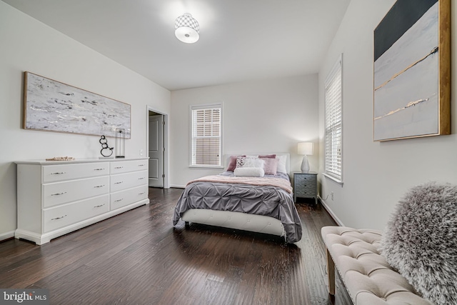 bedroom with dark wood finished floors and baseboards