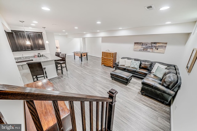 living area with light wood finished floors and recessed lighting