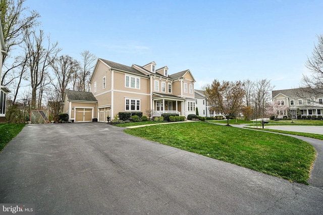 shingle-style home featuring asphalt driveway, a garage, and a front yard