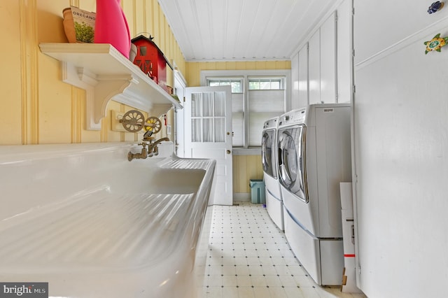 clothes washing area featuring washing machine and clothes dryer, laundry area, and light floors