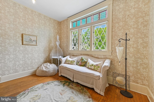 living area featuring baseboards and hardwood / wood-style floors
