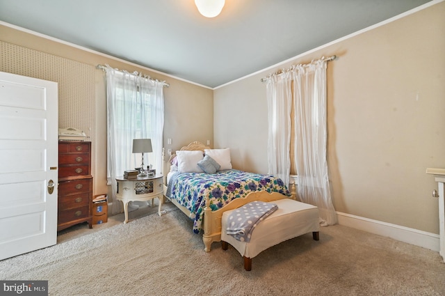 bedroom featuring baseboards, ornamental molding, and carpet