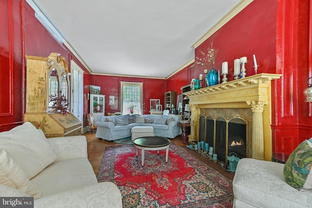living room with crown molding, a fireplace with flush hearth, and wood finished floors