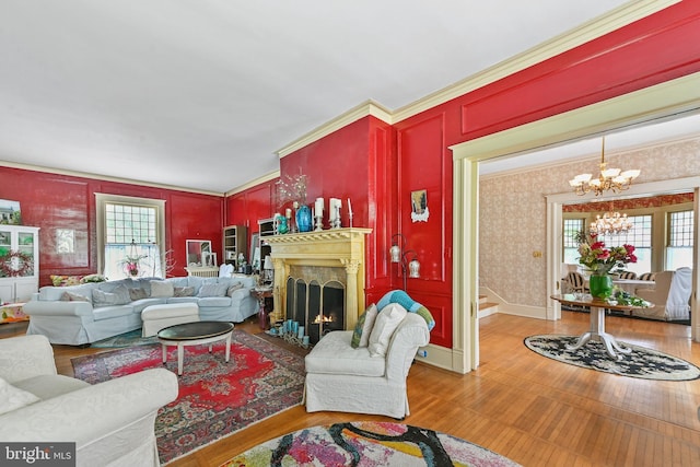living area with a fireplace with flush hearth, plenty of natural light, wood finished floors, and a chandelier