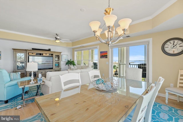 dining area featuring crown molding, visible vents, wood finished floors, baseboards, and ceiling fan with notable chandelier