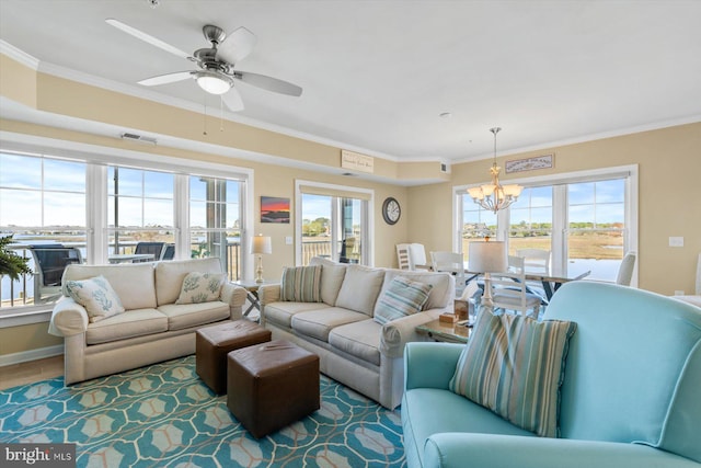 living room featuring visible vents, ornamental molding, and ceiling fan with notable chandelier